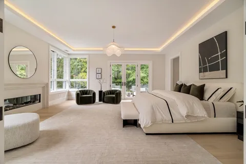 a spacious bedroom with a bed a fireplace and a large window