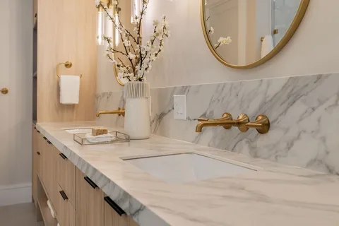 a bathroom with a granite countertop sink a mirror and a shower