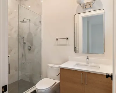 a bathroom with a sink a toilet and shower
