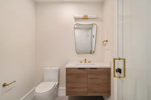 a bathroom with a toilet sink and mirror
