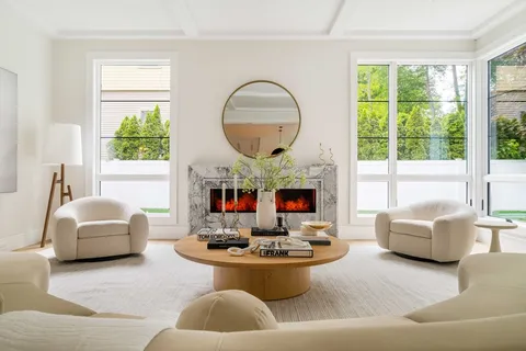 a living room with furniture a fireplace and a large window