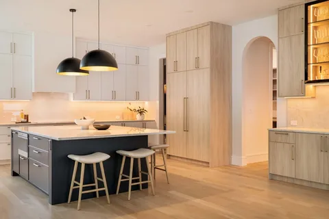 a kitchen with stainless steel appliances granite countertop a sink a stove a refrigerator and island with wooden floor