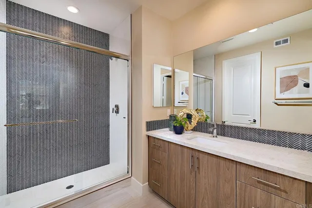 a bathroom with double vanity and a shower
