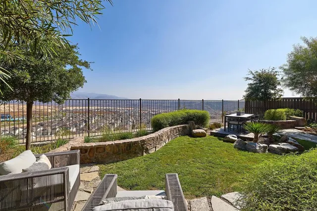 a view of a patio with table and chairs potted plants with wooden fence