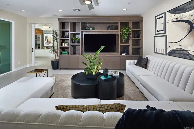 a living room with furniture potted plant and a large window