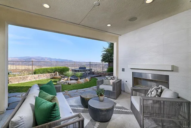 a living room with patio furniture and a garden