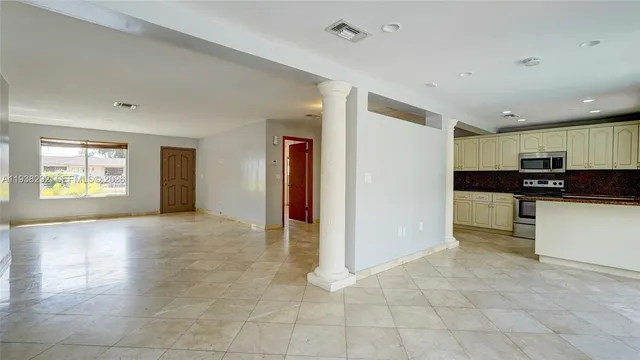 a view of kitchen with stainless steel appliances granite countertop a refrigerator and a stove top oven