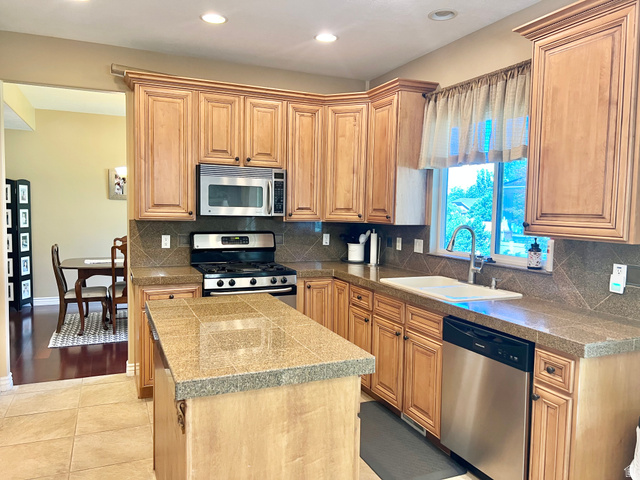 369 Culross Circle Tooele, UT 84074 - Photo 10 of 54 Kitchen featuring recessed lighting, honey-toned cabinetry with crown molding, stainless steel appliances, and a tiled island