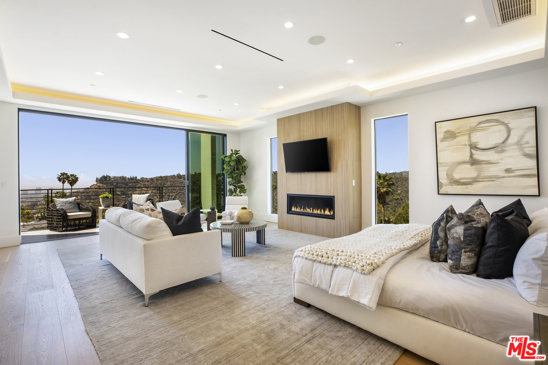 1754 Clear View Drive Beverly Hills, CA 90210 - Photo 25 of 37 a bedroom with a bed a couch and a flat screen tv