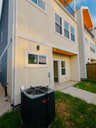 a backyard of a house with barbeque oven and a garden