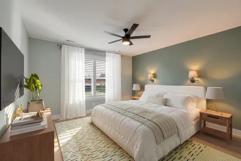 a bedroom with a bed table and a window