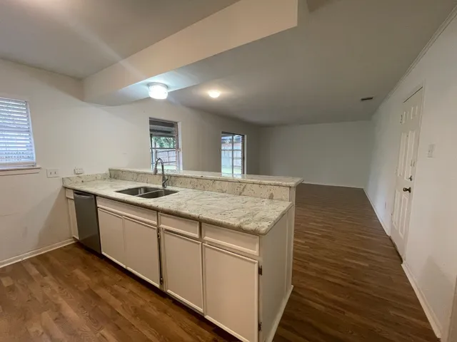 a kitchen with granite countertop sink stove and cabinets