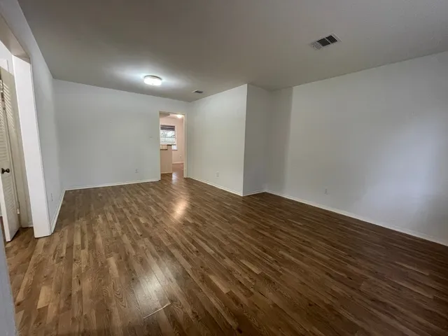 a view of empty room with wooden floor