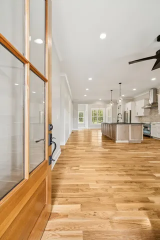 a view of a kitchen with kitchen island wooden floor and a fireplace