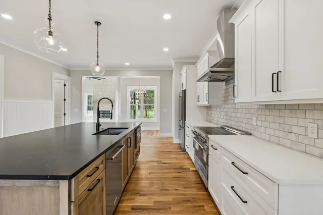 a kitchen with granite countertop a sink stainless steel appliances and cabinets