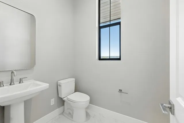 a bathroom with a toilet a sink and mirror