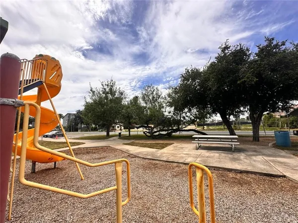 a view of swimming pool with outdoor seating and trees in the background