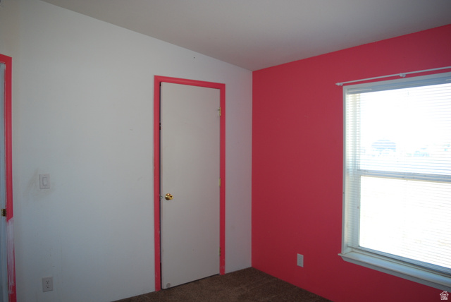 1055 West Ashby Road Delta, UT 84624 - Photo 26 of 44 Room featuring a bright accent wall, neutral carpeting, and a window with blinds