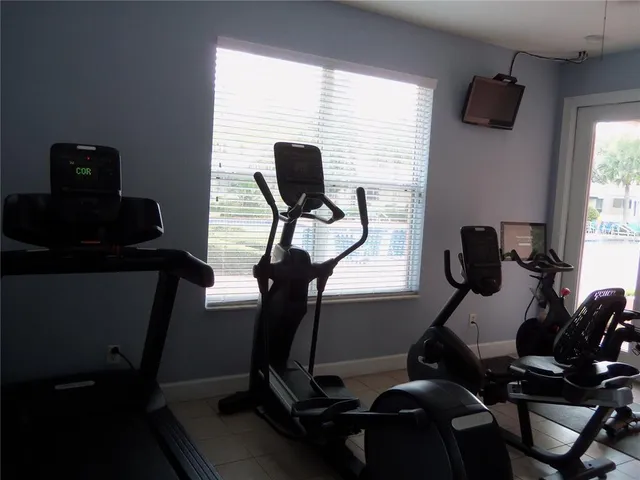 an empty room with a window and ceiling fan