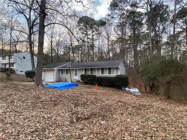 a front view of a house with yard porch and covered with green space