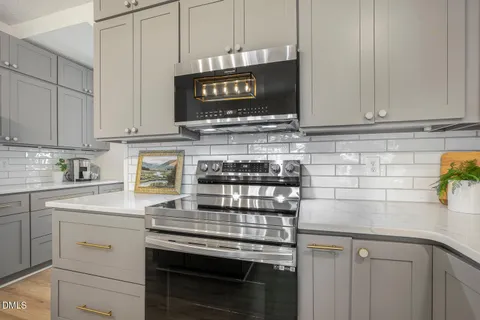 a kitchen with cabinets appliances a sink and a counter top space