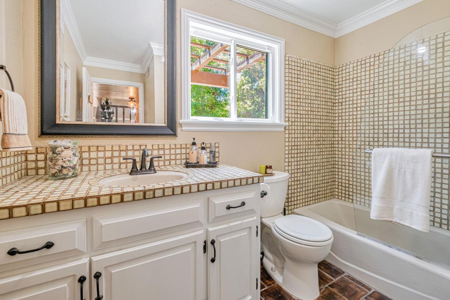 4858 Freedom Boulevard Aptos, CA 95003 - Photo 12 of 65 a bathroom with a granite countertop toilet a sink a mirror and a window