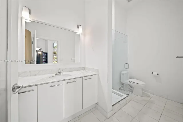 a spacious bathroom with a granite countertop sink toilet and mirror