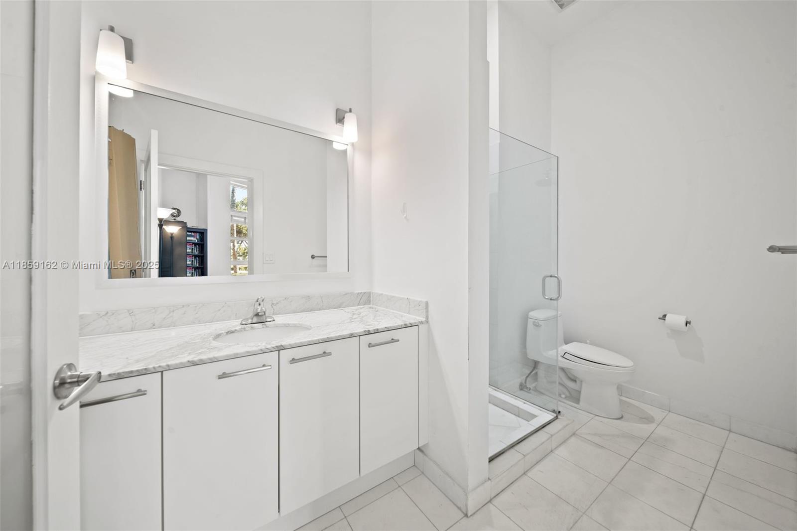 2001 Meridian Avenue, Unit 103 Miami Beach, FL 33139 - Photo 24 of 49 a spacious bathroom with a granite countertop sink toilet and mirror
