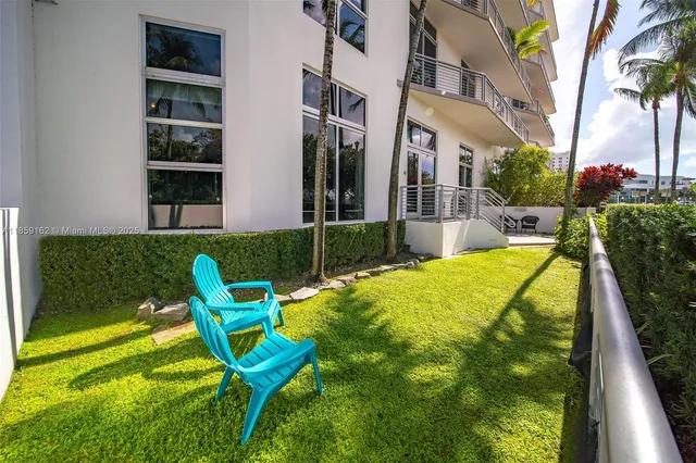 a view of a swimming pool with two chairs in a yard
