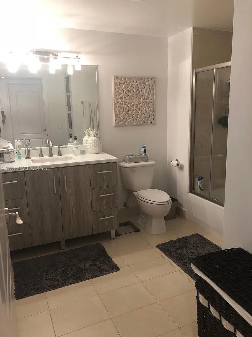 2400 Southwest 27th Avenue, Unit 304 Miami, FL 33145 - Photo 11 of 18 a bathroom with a sink toilet and a mirror