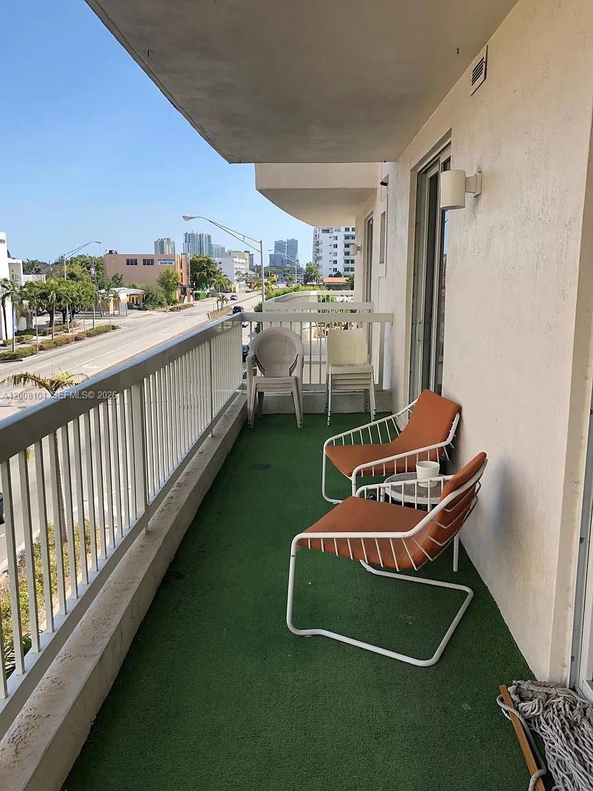2400 Southwest 27th Avenue, Unit 304 Miami, FL 33145 - Photo 13 of 18 a balcony with a bench and city view