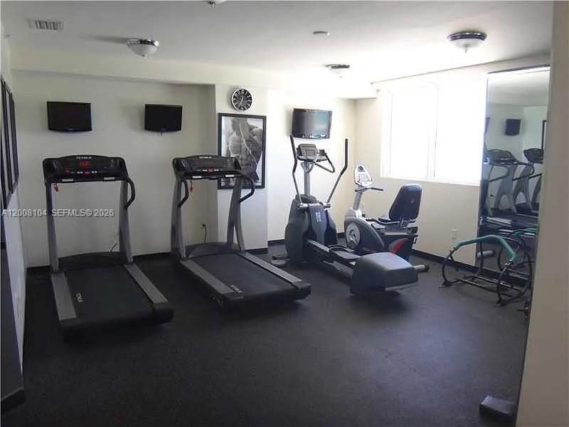 2400 Southwest 27th Avenue, Unit 304 Miami, FL 33145 - Photo 18 of 18 a room with gym equipment and a view of living room