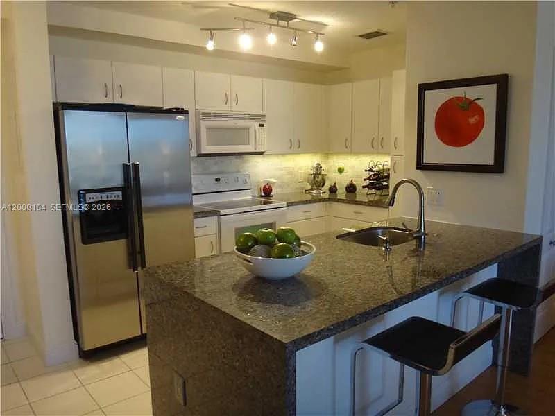 2400 Southwest 27th Avenue, Unit 304 Miami, FL 33145 - Photo 3 of 18 a kitchen with a sink appliances and cabinets