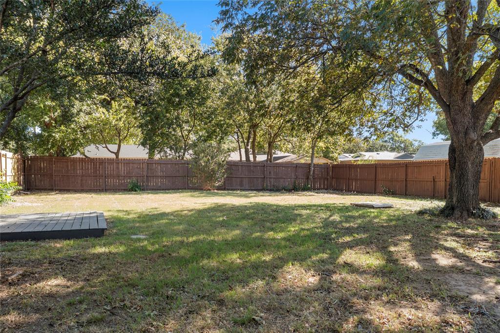 2221 North Alexander Street Sherman, TX 75092 - Photo 22 of 39 a view of a yard with a large tree and wooden fence
