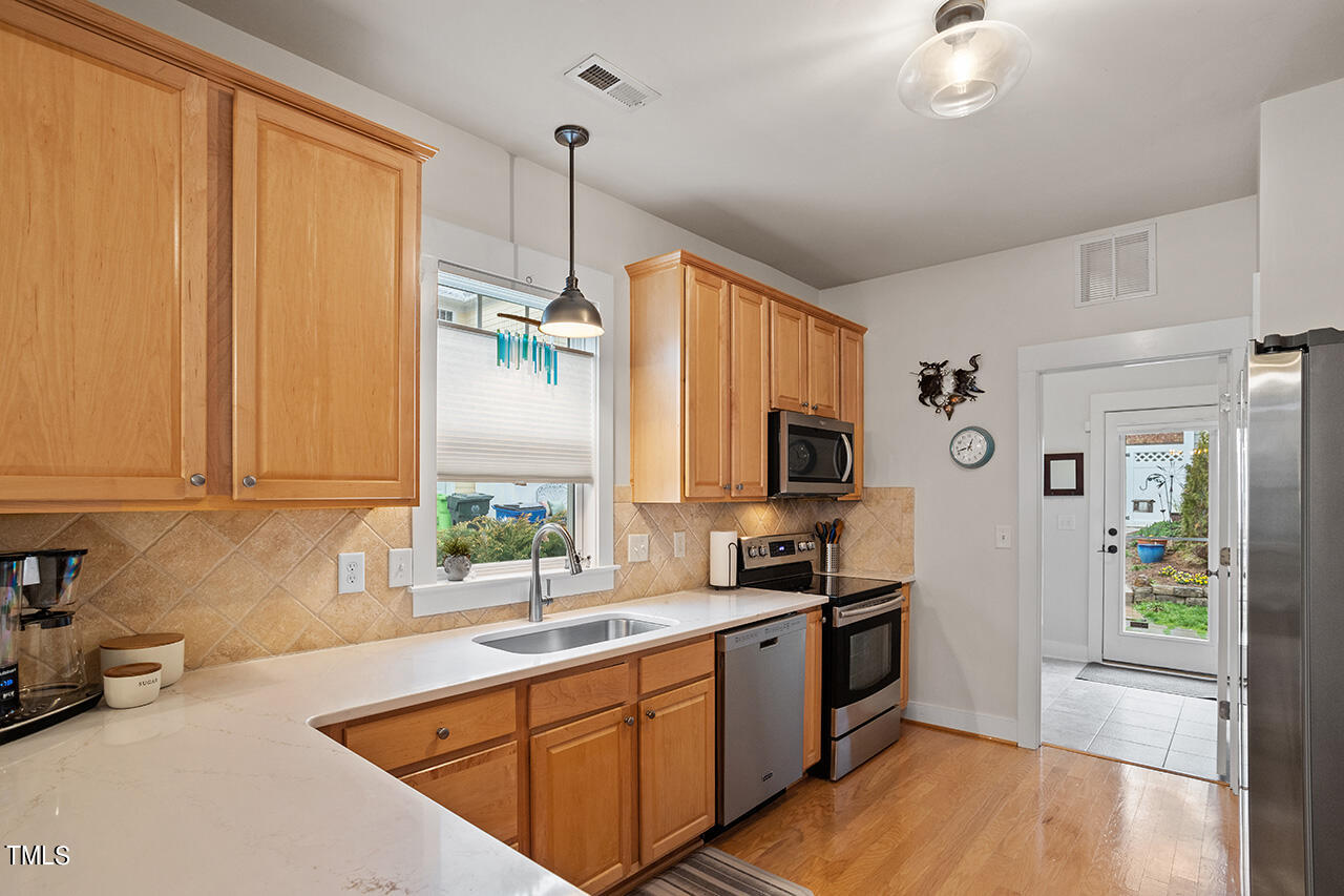 4526 All Points View Way Raleigh, NC 27614 - Photo 7 of 25 a kitchen with stainless steel appliances a sink dishwasher a refrigerator and a stove with wooden floor