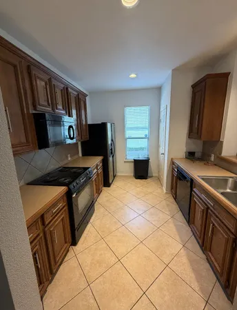 a kitchen with granite countertop a stove and a refrigerator