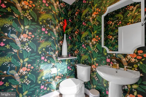 a bathroom with a toilet sink and mirror