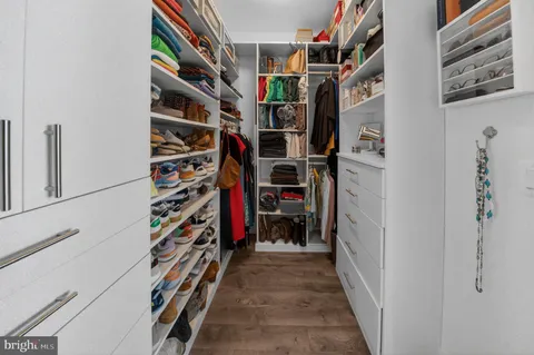 a view of walk in closet with clothes and shoes