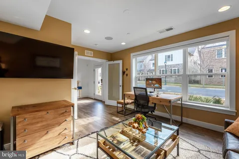 a living room with furniture a flat screen tv and a table