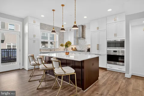 a kitchen with stainless steel appliances a dining table chairs stove and cabinets