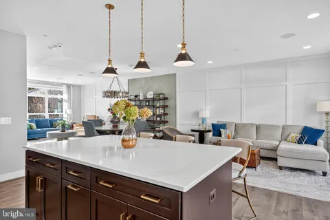a view of a kitchen with kitchen island stainless steel appliances a sink and living room view
