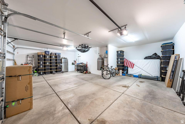 5963 Flattop Drive St. George, UT 84790 - Photo 45 of 45 Spacious garage with concrete flooring, multiple overhead lighting fixtures, a ceiling-mounted fan, and an accessible water heater