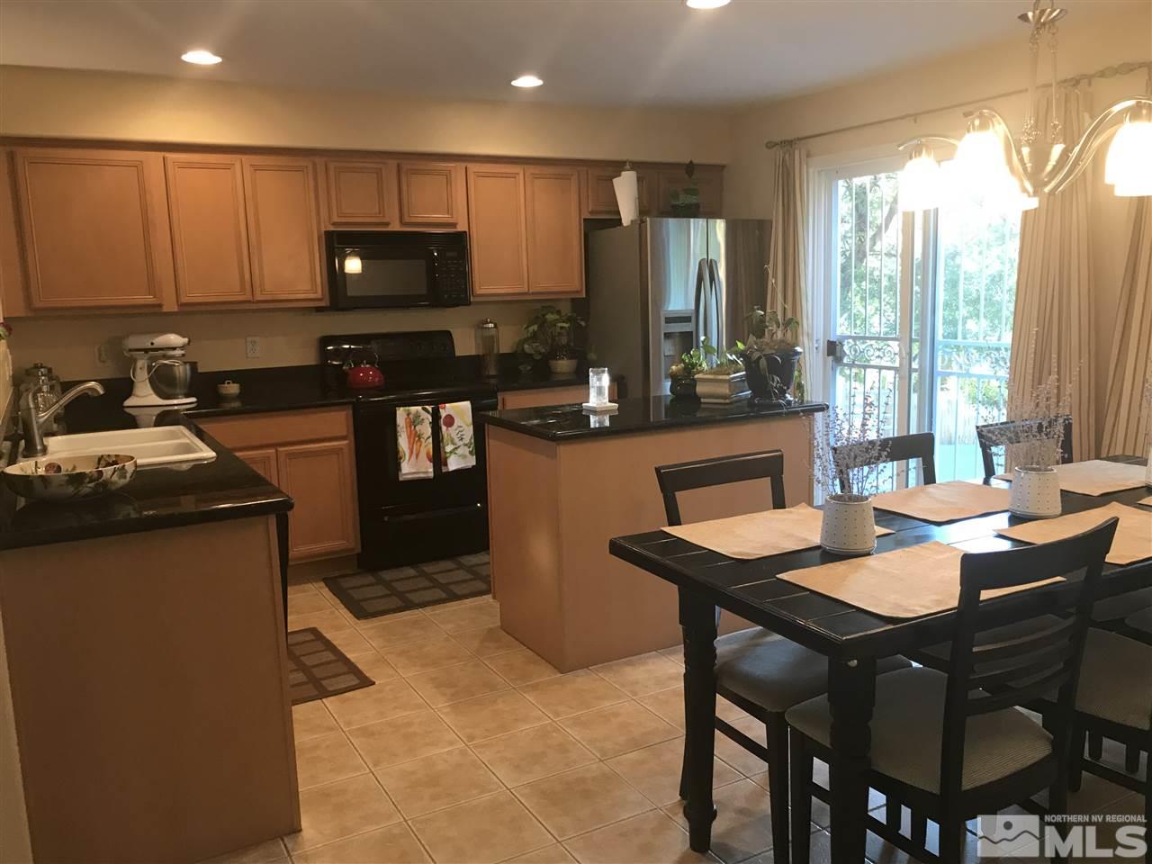 1185 Coleman Drive Reno, NV 89503 - Photo 3 of 13 a kitchen with stainless steel appliances kitchen island granite countertop a stove a refrigerator a sink and a dining table with chairs