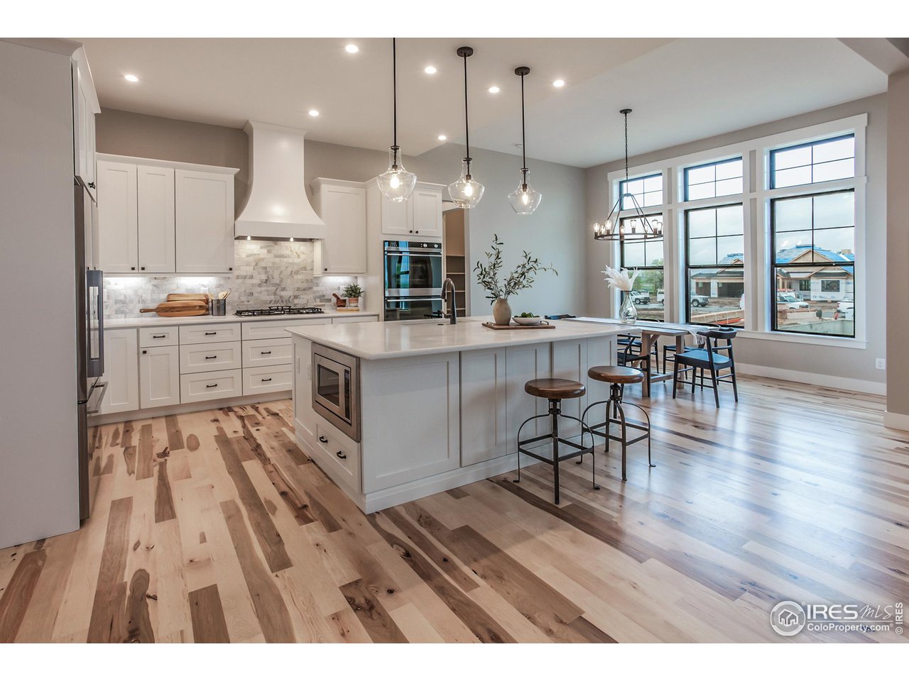 1293 Burt Avenue Berthoud, CO 80513 - Photo 14 of 40 a large kitchen with cabinets chairs and wooden floor