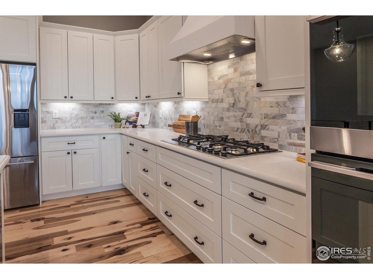 1293 Burt Avenue Berthoud, CO 80513 - Photo 19 of 40 a kitchen with granite countertop white cabinets and stainless steel appliances