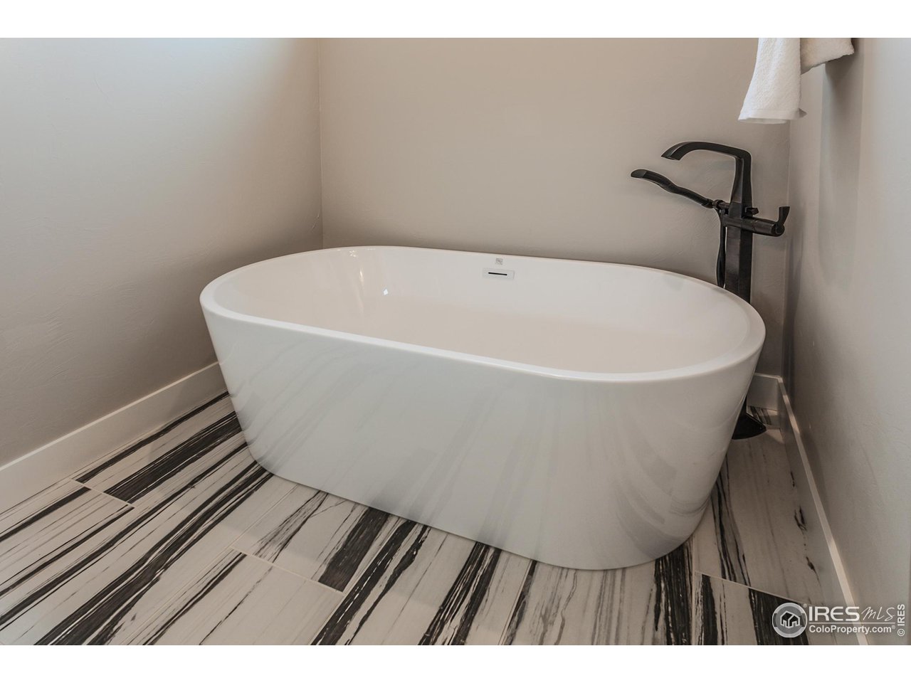 1293 Burt Avenue Berthoud, CO 80513 - Photo 25 of 40 a white bath tub sitting in a bathroom