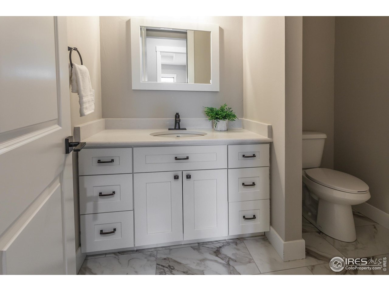 1293 Burt Avenue Berthoud, CO 80513 - Photo 26 of 40 a bathroom with a toilet a sink a vanity and mirror