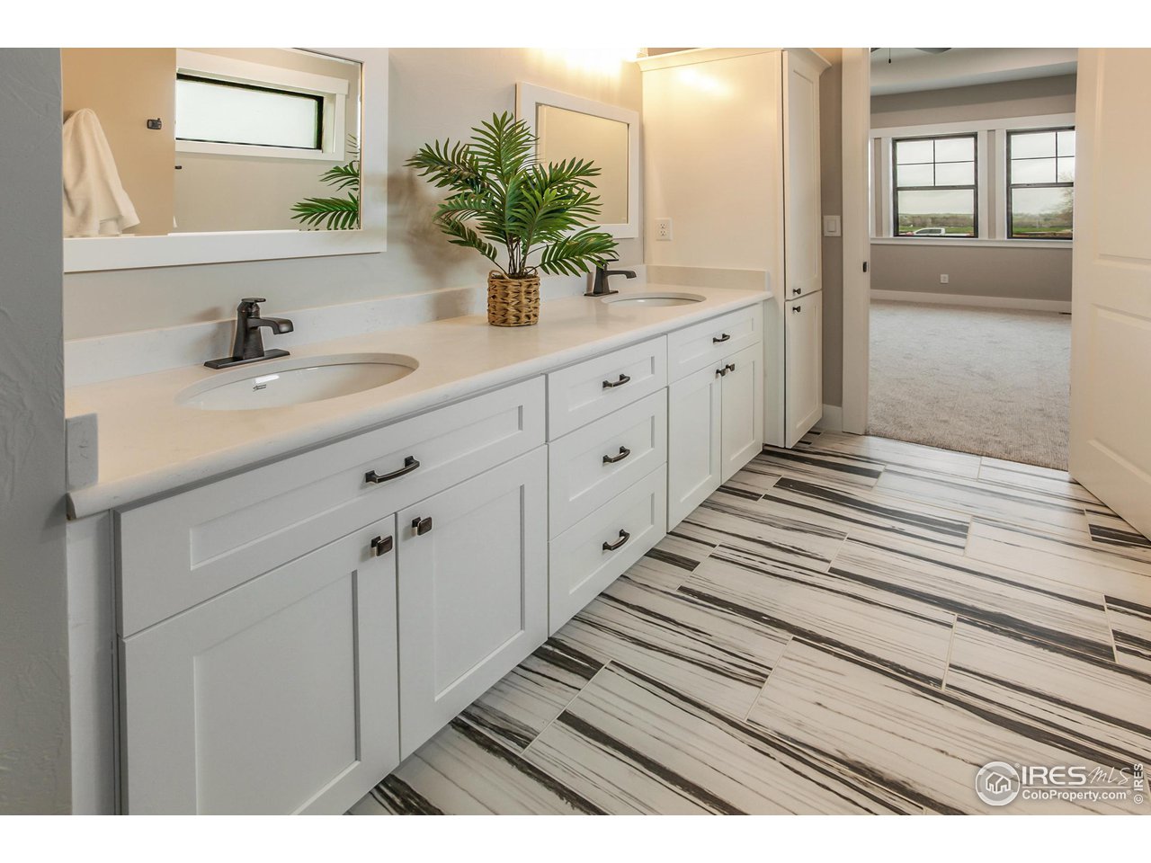 1293 Burt Avenue Berthoud, CO 80513 - Photo 28 of 40 a bathroom with a double vanity sink and mirror