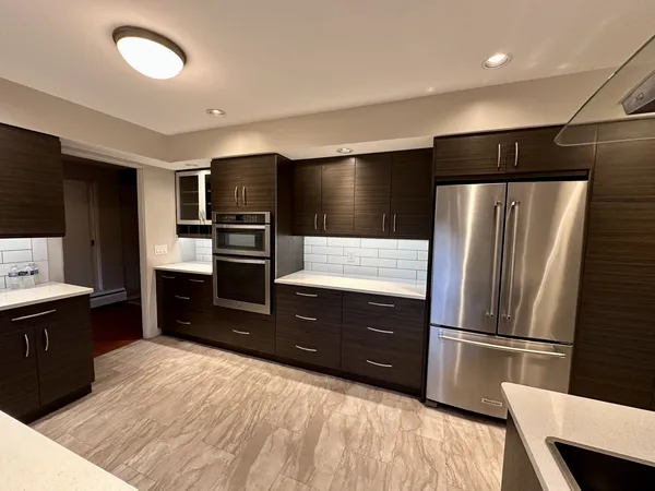 a kitchen with granite countertop a refrigerator and a sink
