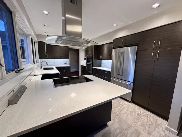a kitchen with stainless steel appliances a refrigerator and a stove top oven